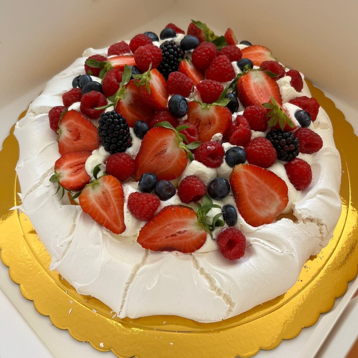 Pavlova con nata y frutos del bosque