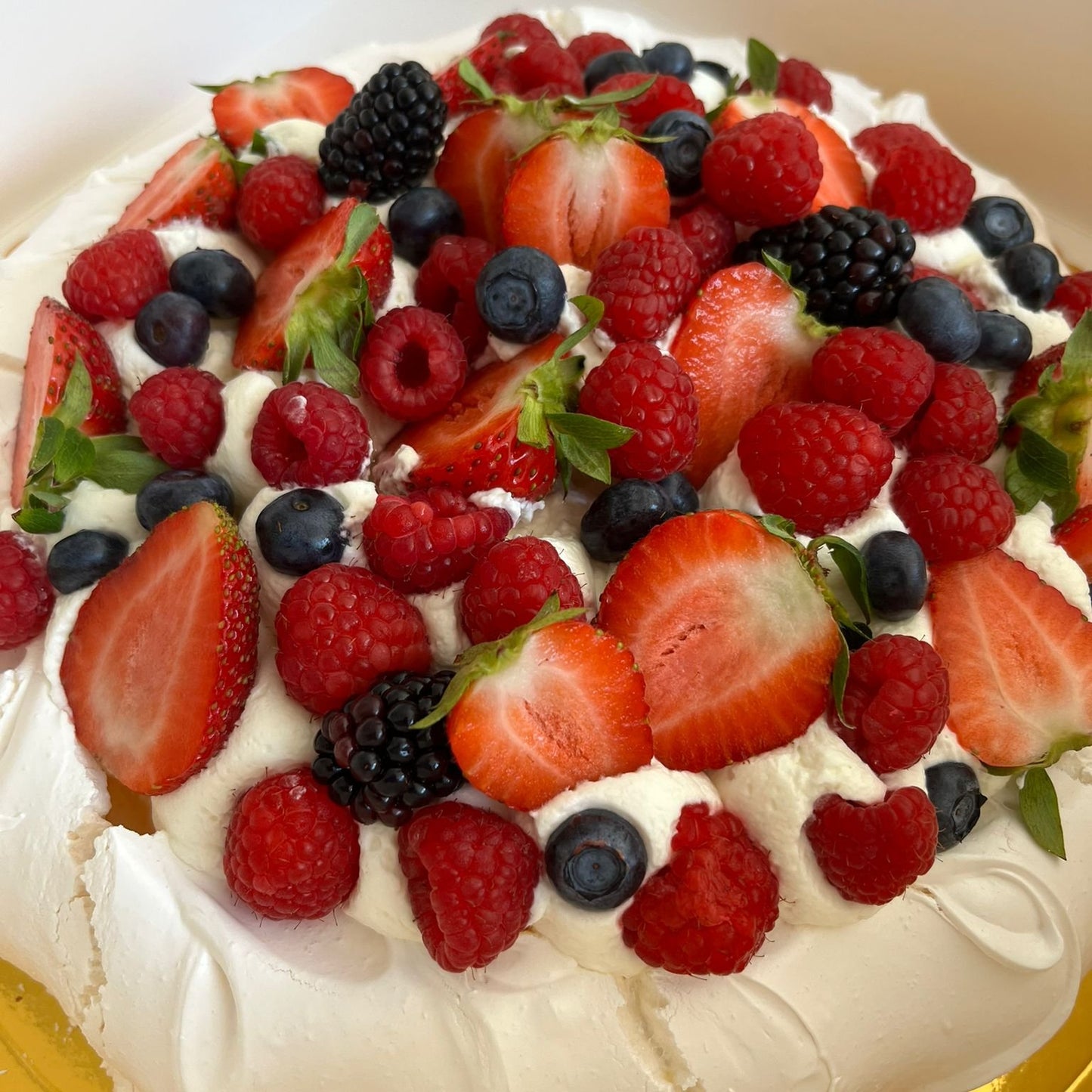 Pavlova con nata y frutos del bosque