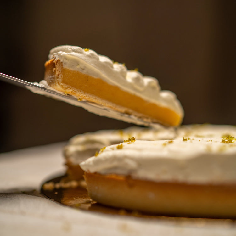 Tarta Lemon Pie favorita de los clientes, destacada por su presentación elegante y su relleno cremoso de limón.