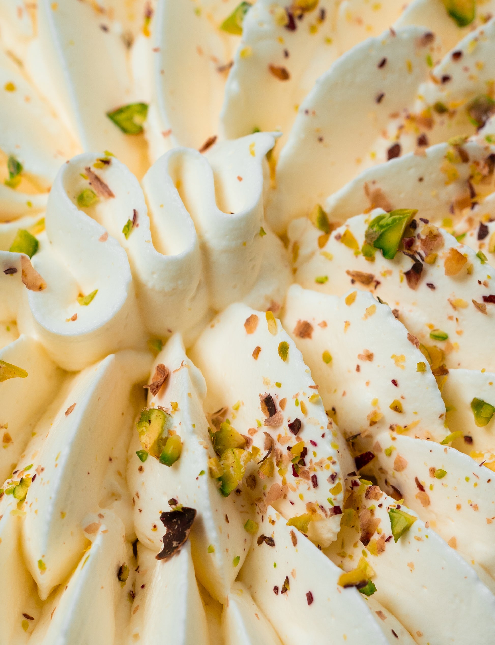 Primer plano del Fraisier Millington Cakes que resalta la textura suave de la muselina, las fresas frescas y el toque crujiente de pistacho.