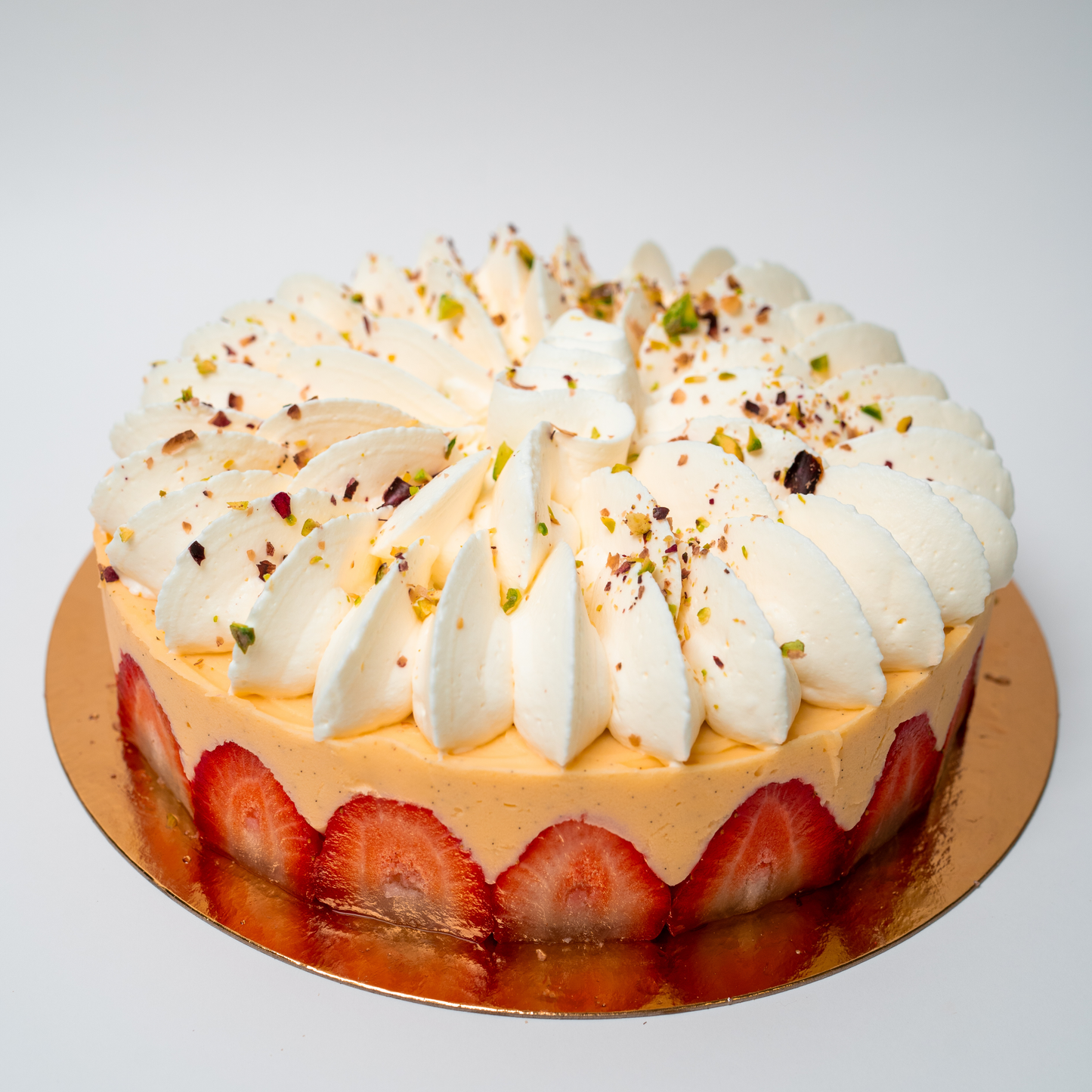 Fraisier Millington Cakes con bizcocho genoise, muselina suave y fresas frescas, decorado con un toque de pistacho.